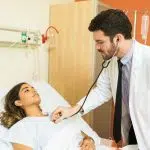 e arts die patiënt met stethoscoop onderzoekt in het ziekenhuis