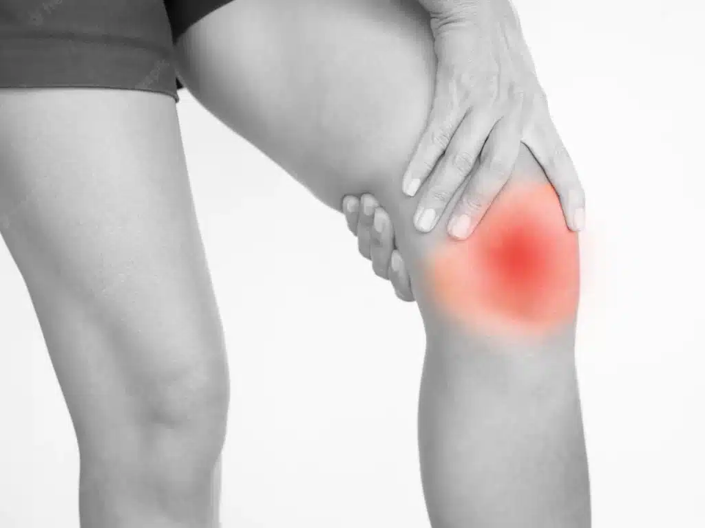 De afbeelding toont een knie met een rood gemarkeerd gebied, wat duidt op kniepijn.