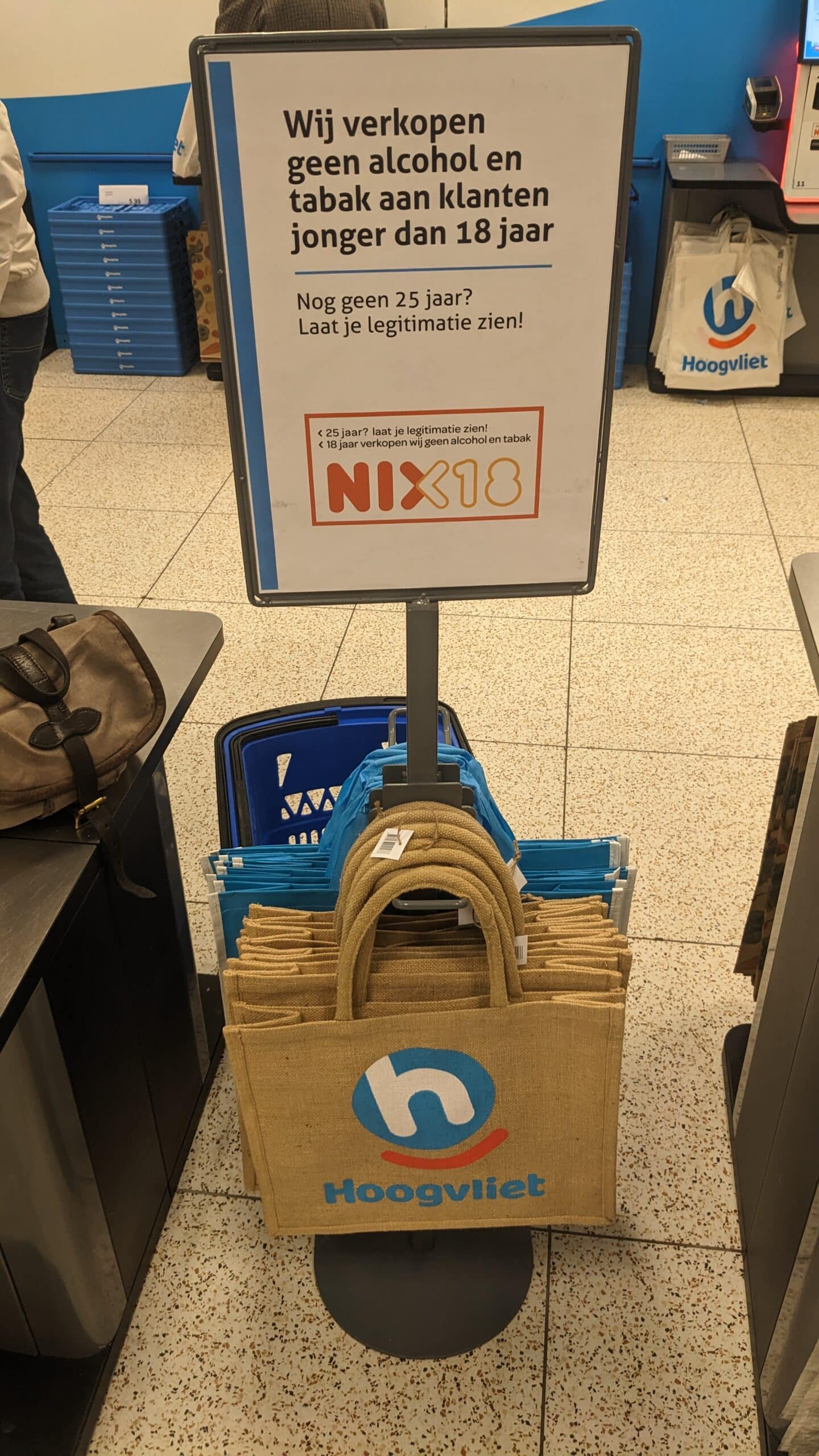 Waarschuwingsbord bij Hoogvliet-supermarkt met de tekst dat er geen alcohol en tabak wordt verkocht aan klanten onder de 18 jaar (NIX18-campagne). De foto is gemaakt in het filiaal Kleiwegkwartier, Rotterdam, 2023.