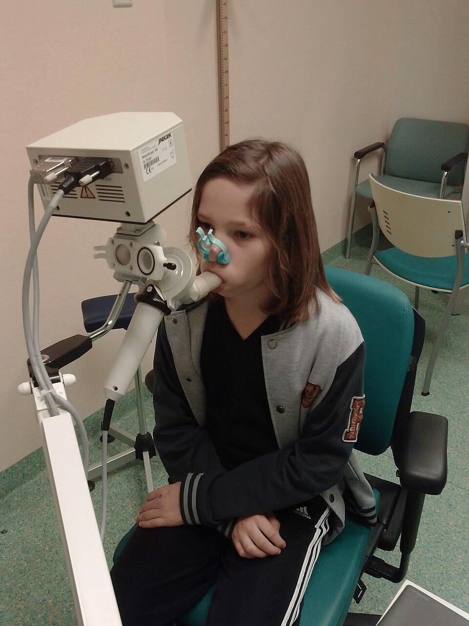 Een kind blaast in een spirometer tijdens een longfunctieonderzoek; een eenvoudige maar nauwkeurige test om te beoordelen hoe goed de luchtwegen werken bij astma of andere longklachten.