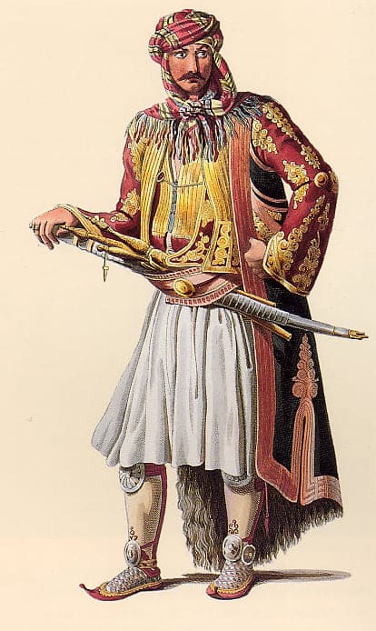 Negentiende-eeuwse illustratie van een janitsaar uit Ioannina, gekleed in rijk versierde Ottomaanse kleding met tulband, sabel en vuurwapen.